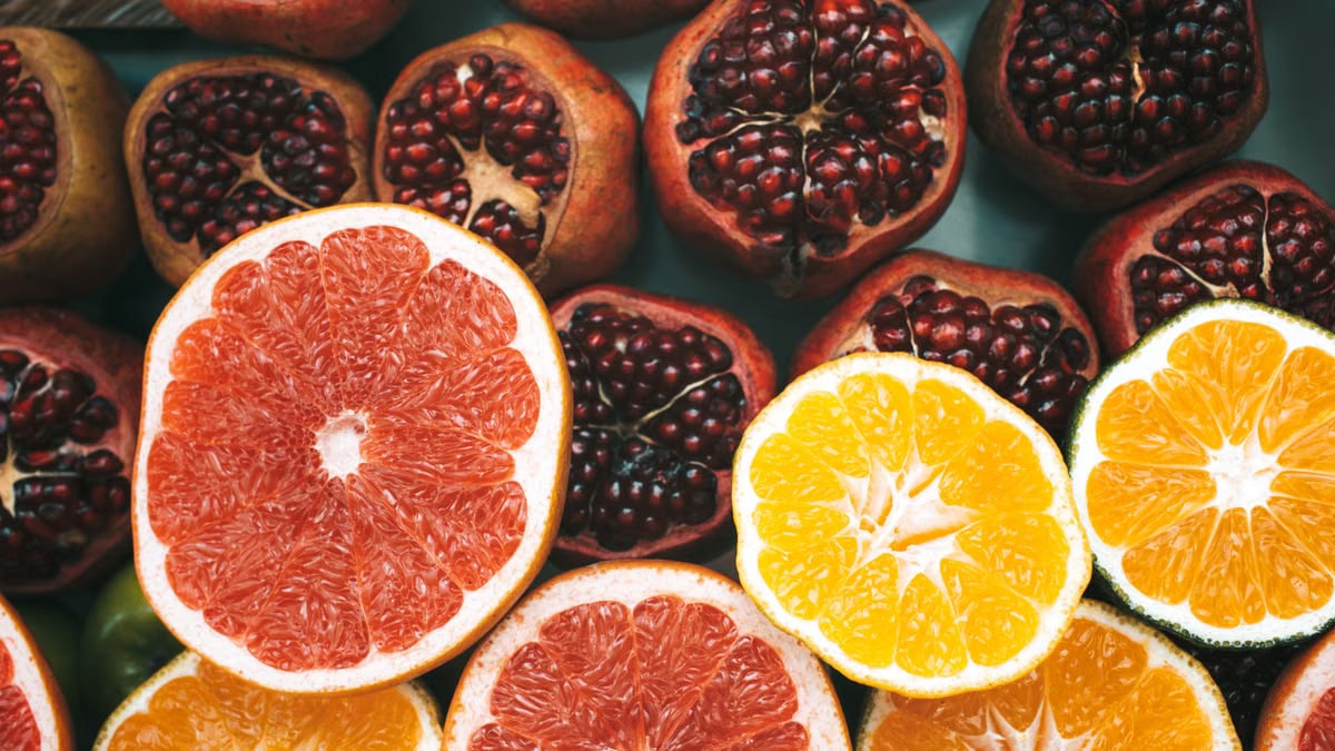 Close-up view of colorful sliced citrus fruits and pomegranates showcasing freshness and nutrition.